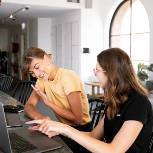 Two women speaking in front of a computer